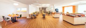 a restaurant with tables and chairs in a room at Hotel La Mirabelle in Rheinhausen