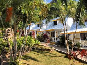 una casa con palmeras delante en Cabañas Agua Dulce, en Providencia