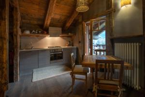 uma cozinha com uma mesa de madeira e uma sala de jantar em Chalet Svizzero Apartments em Courmayeur