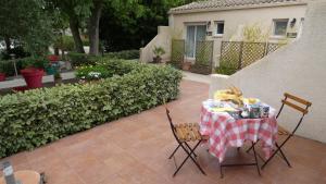 une table avec un chiffon de table rouge et blanc dans l'établissement Chambres d'hôtes La Gardie, à Vias