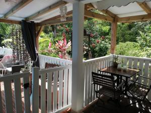 a porch with a table and chairs on it at Les Gîtes de CASITA By kreyol animal in Grand-Bourg