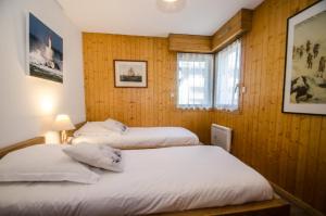 Duas camas num quarto com painéis de madeira em Résidence Clos Du Savoy em Chamonix-Mont-Blanc