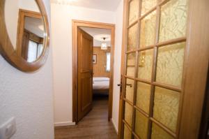 einen Flur mit einem Spiegel und eine Tür mit einem Schlafzimmer in der Unterkunft Résidence Clos Du Savoy in Chamonix-Mont-Blanc