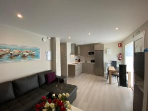 a living room with a couch and a kitchen at Apartamentos La Ardina Celorio in Celorio