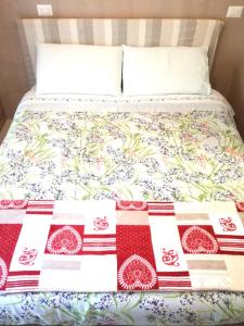 Una cama con un edredón rojo y blanco. en Appartamento Lavanda Garda, en Garda