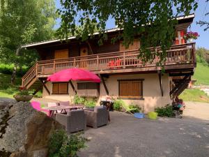 a house with a balcony and a table and chairs at APPARTEMENT VUE SUR LES PISTES Aux SAISIES 4 in Les Saisies