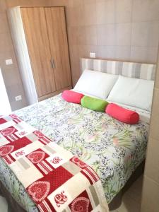 Una cama con manta y almohadas. en Appartamento Lavanda Garda, en Garda