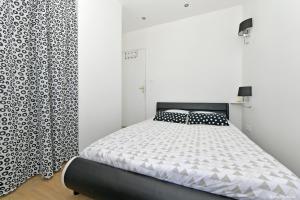 a bedroom with a bed and a black and white curtain at Comme à la Maison - DE LA TOUR in Saint-Quentin