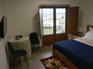a bedroom with a bed and a table and a window at Casa das Olmedas in Vimioso +17 photos