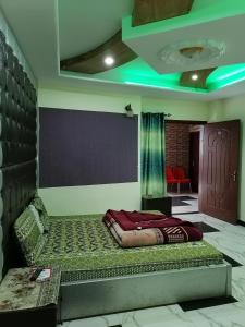 a bed in a room with a green light at Ayub Residence Bhurban in Murree