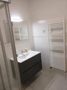 a white bathroom with a sink and a shower at Casa das Olmedas in Vimioso