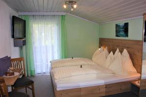 ein Schlafzimmer mit einem großen Bett mit weißen Kissen in der Unterkunft Gästehaus Oberauer in Annaberg im Lammertal