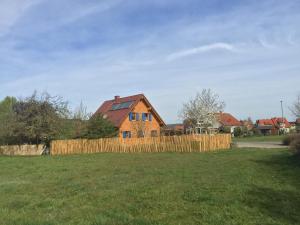 a house behind a wooden fence in a field at Tinyhouse Bamberg in Pettstadt