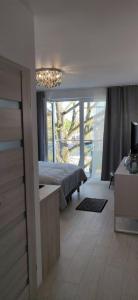 een slaapkamer met een bed en een groot raam bij Apartamenty Hugo Centrum in Słupsk