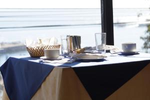 a table with a blue and white table cloth and a window at Hotel Puerto Mayor in San Antonio