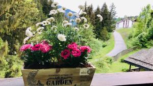 a pot of flowers sitting on top of a table at Ferienwohnung Laax mit Traumblick, großem Balkon und Terrasse in Laax