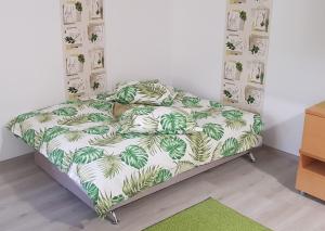 um quarto com uma cama com um edredão verde e branco em Green Apartman em Târgu-Mureş