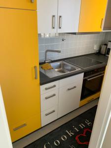 a kitchen with a sink and a yellow door at FeWo Merle in Büsum