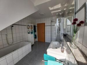 ein Badezimmer mit Waschbecken und Badewanne und Waschbecken in der Unterkunft Tova Cologne in Großkönigsdorf + 19 Fotos