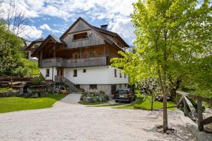 une grande maison avec une voiture garée dans l'allée dans l'établissement Apartments Mlin, à Bohinj