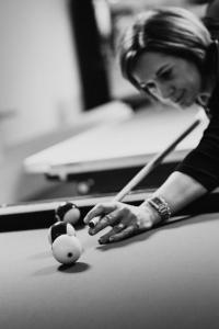 Eine Frau spielt Billard in der Unterkunft Hotel Reich in Cazis