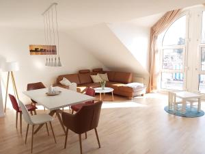 uma sala de estar com uma mesa e cadeiras e um sofá em Tova Cologne em Großkönigsdorf