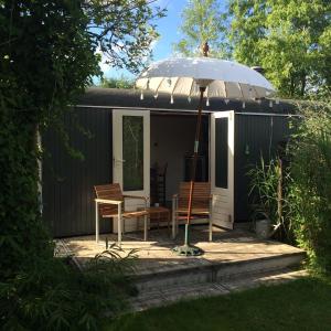 a gazebo with two chairs and an umbrella at Gipsy wagon near Amsterdam and beach in Velserbroek 