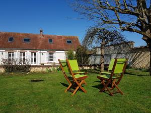 two chairs sitting in the grass in front of a house at L'havre de Saint Germain in Saint-Germain-sur-Avre +44 photos