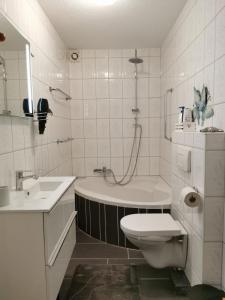 ein Badezimmer mit einer Badewanne, einem WC und einem Waschbecken in der Unterkunft Ferienwohnung Altstadt in Rottenburg