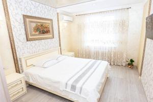 - une chambre avec un lit blanc et une fenêtre dans l'établissement Тараскова 16, Люкс, ЮЗР, à Tcherkassy