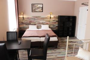 a bedroom with a bed with a brick wall at Promenade Panzió in Miskolc