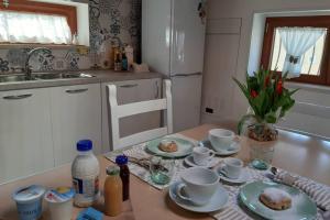 a kitchen with a table with cups and saucers on it at APPARTAMENT '' IL GIARDINO '' in Santa Maria La Carità +46 photos
