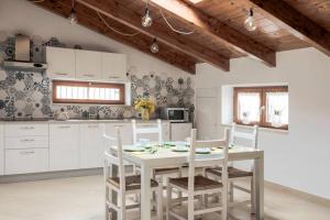 a kitchen with a white table and chairs at APPARTAMENT '' IL GIARDINO '' in Santa Maria La Carità