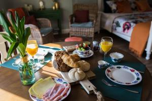 een tafel met brood en glazen sinaasappelsap en sinaasappelsap bij B&B Wilhelmina's Cottage in Ridderkerk