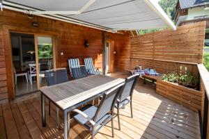une terrasse en bois avec une table et des chaises en bois dans l'établissement Apartments Mlin, à Bohinj