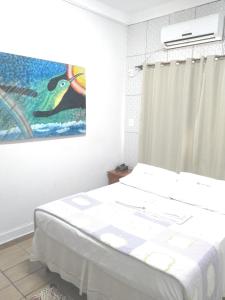 1 dormitorio con 1 cama y una pintura en la pared en Hotel Araguaia Goiânia, en Goiânia