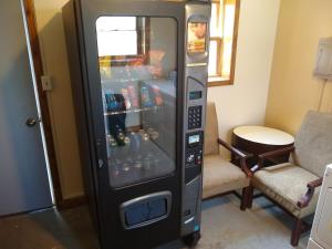 a vending machine in a room with two chairs at Townhouse Motel in Lusk