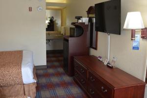 a hotel room with a bed and a television at Travelodge by Wyndham Montgomery East in Montgomery