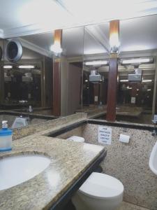 y baño con 2 lavabos, aseo y espejo. en Hotel Araguaia Goiânia en Goiânia