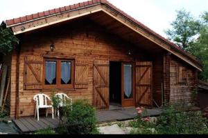 a wooden cabin with two chairs on a deck at Charme Z'Aisne in Louâtre