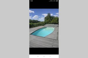 a screenshot of a cell phone screen showing a swimming pool at Charme Z'Aisne in Louâtre