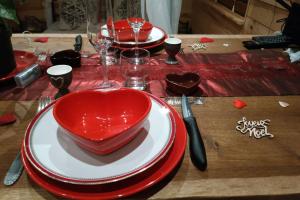 a table with red and white plates and a heart shaped bowl at Charme Z'Aisne in Louâtre