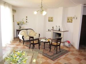 Magralù 2 B&B في ألغيرو: غرفة معيشة مع طاولة وكراسي ومدفأة