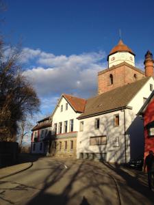 een wit gebouw met een klokkentoren op een straat bij Gasthaus Römer in Haigerloch