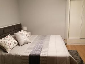 un letto con due cuscini sopra in una camera da letto di Casa Cima de Vila a Vieira do Minho Altre 18 foto