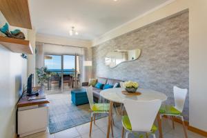 ein Esszimmer und ein Wohnzimmer mit einem Tisch und Stühlen in der Unterkunft Beach front apartment Barracuda Albufeira in Albufeira