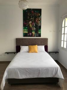 a bedroom with a large white bed with a yellow pillow at Larq'a Park Rooms in Lima