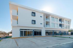 un grand bâtiment blanc avec un parking dans l'établissement Heaven Hotel, à Playa del Carmen