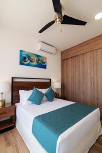 um quarto com uma cama e uma ventoinha de tecto em Heaven Hotel em Playa del Carmen