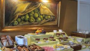a table filled with food with a painting on the wall at Solar De La Plaza in Salta